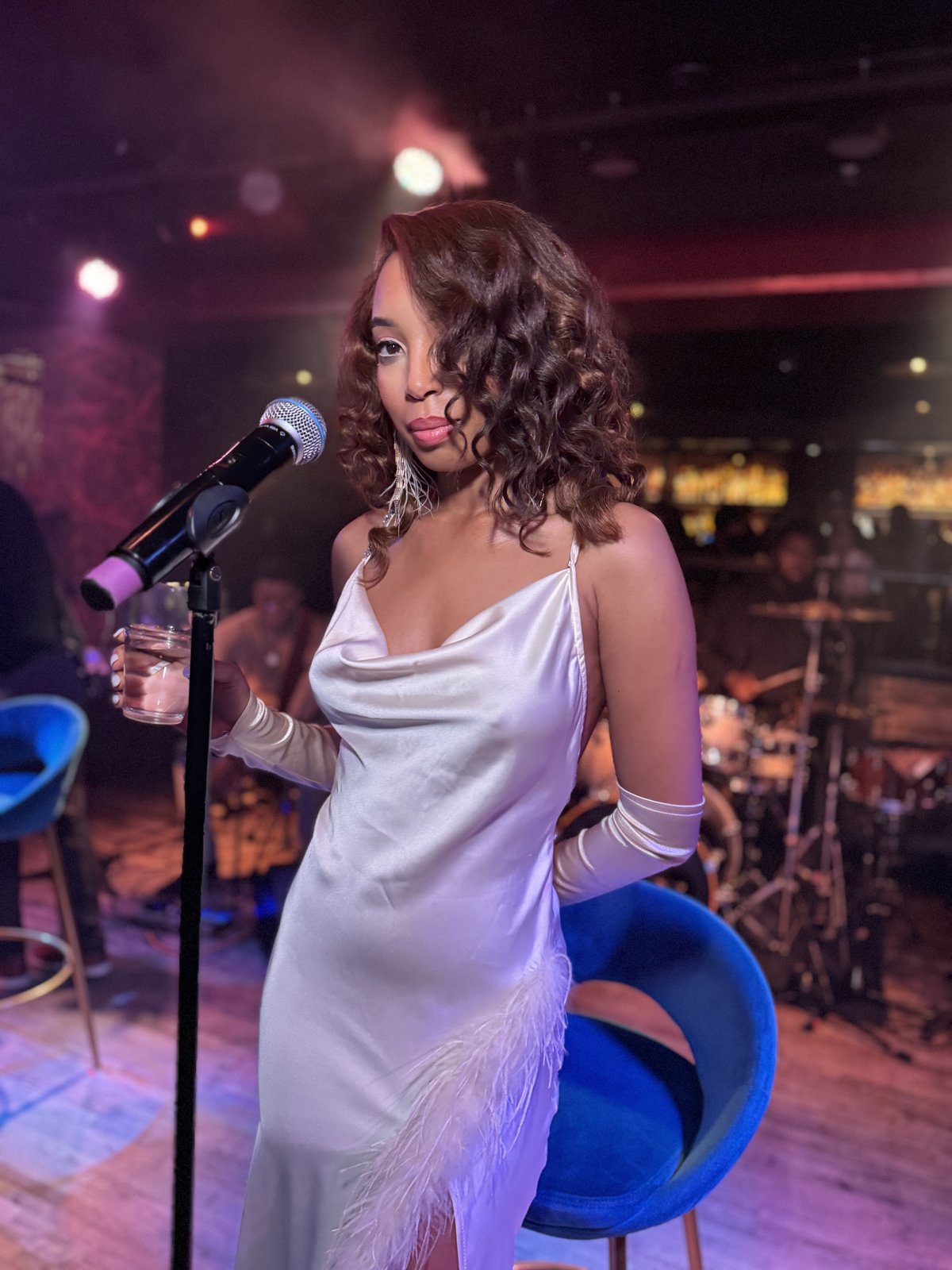 Aerie Williams in a white satin slip dress at the microphone, live at Untitled Supper Club, Chicago, 2026
